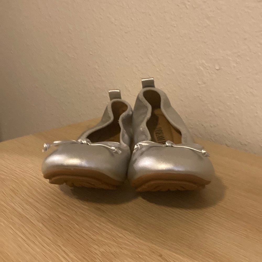 Silver slip on flats with bow.